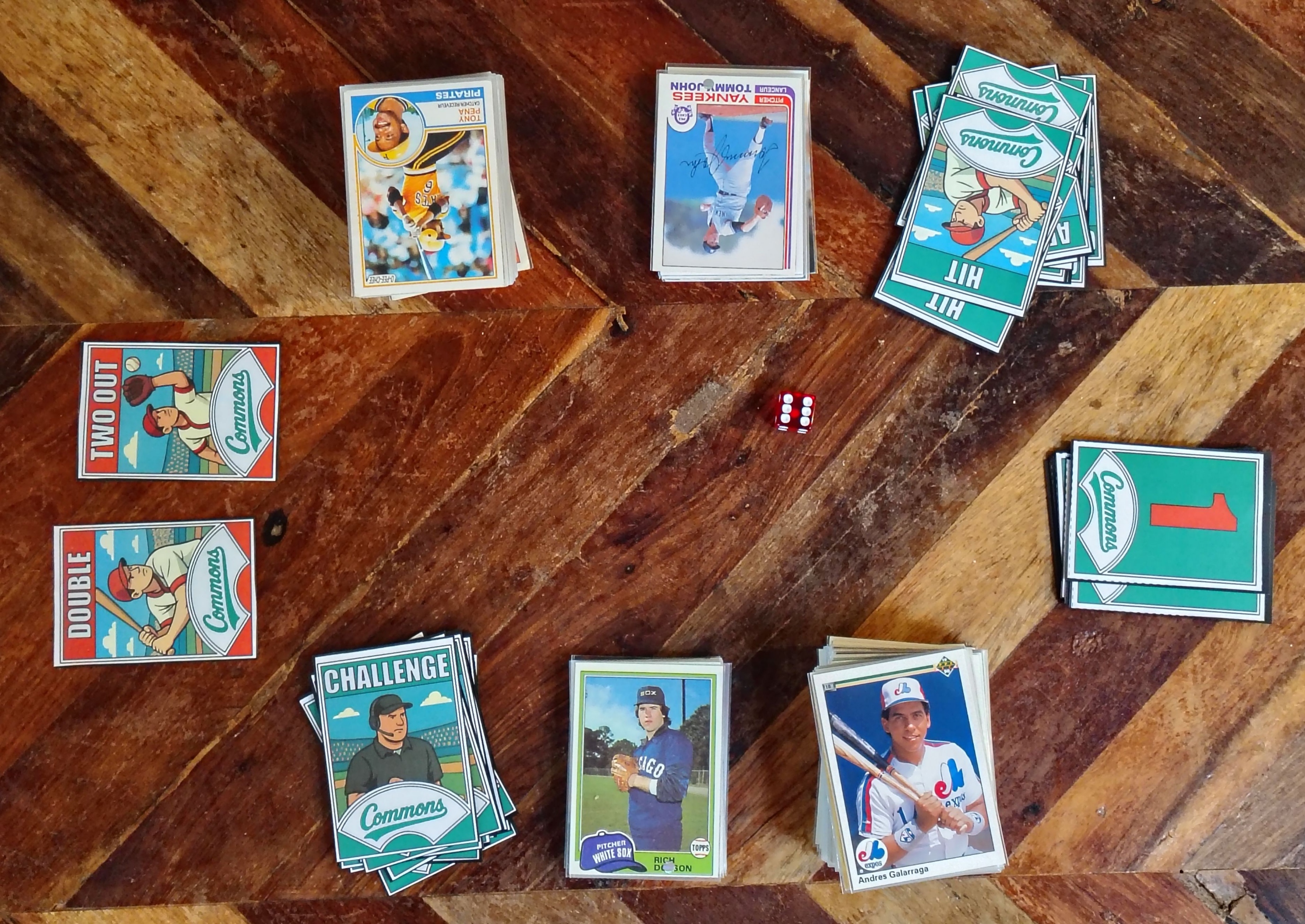 A typical game setup showing cards, a single die, and baseball gods cards laid out on a table